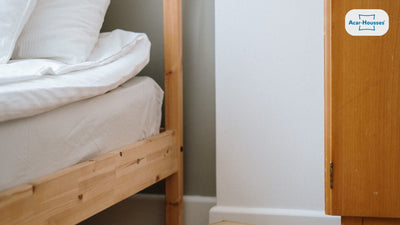 Lit sur cadre en bois clair avec matelas et couette blanche, sans sommier tapissier